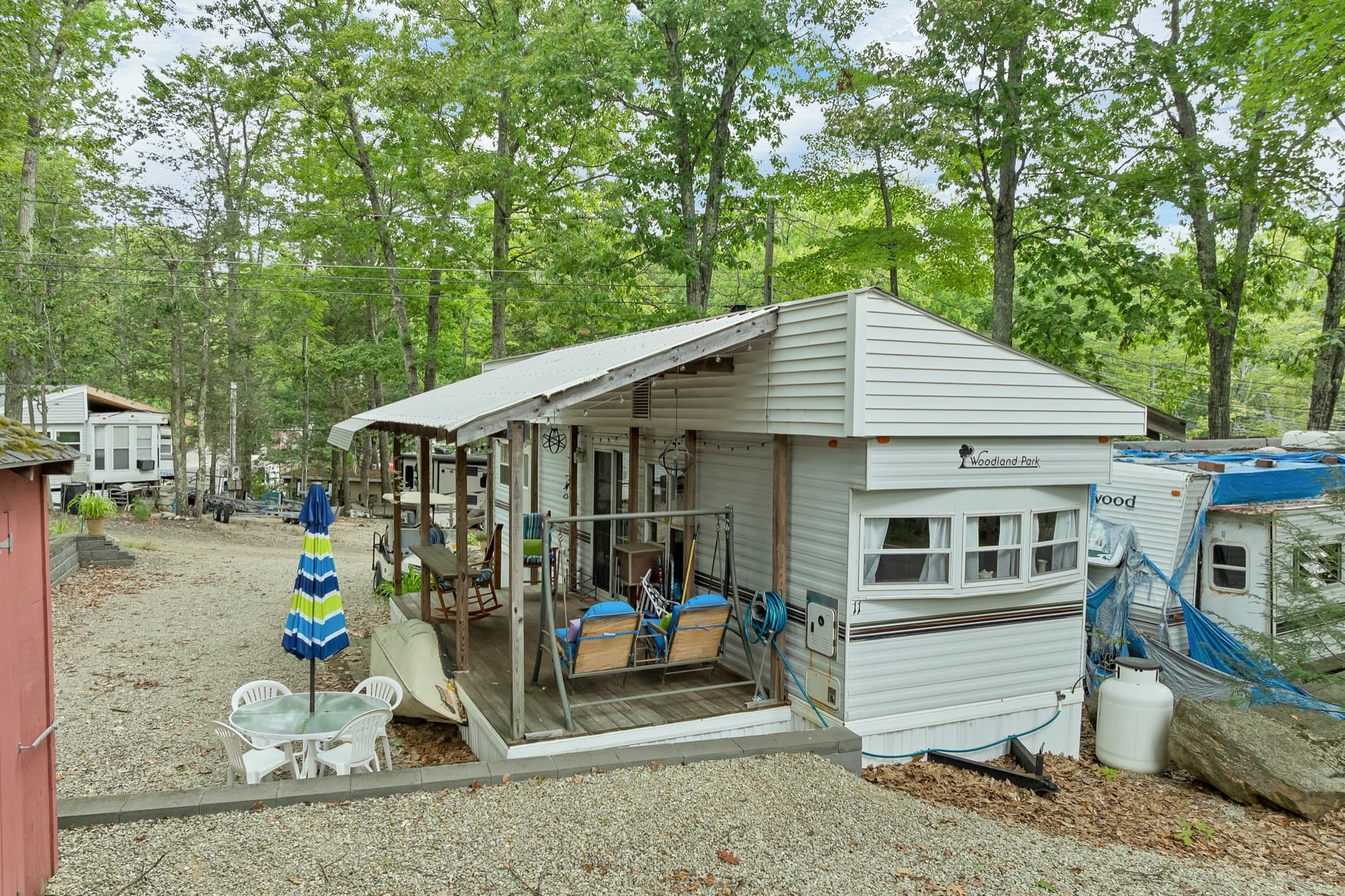 The Woodland Park unit from the front corner, with the canopy and deck and the patio set