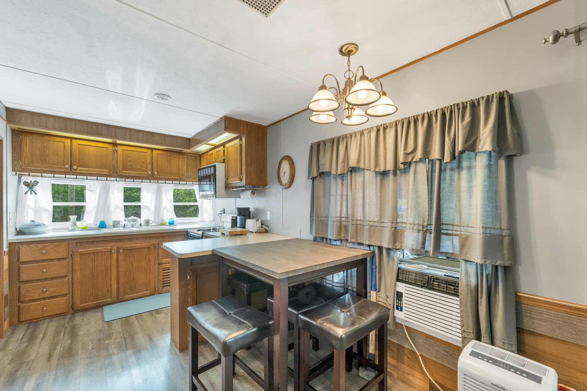 The dining table and stools by the window, with the wall air conditioner
